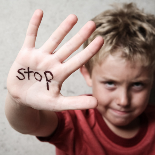 Boy with the word 'stop' written on his hand